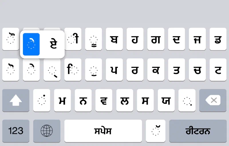 The Punjabi keyboard with a vowel-sign key held down. A popup offers the vowel sign itself and its matching independent vowel.